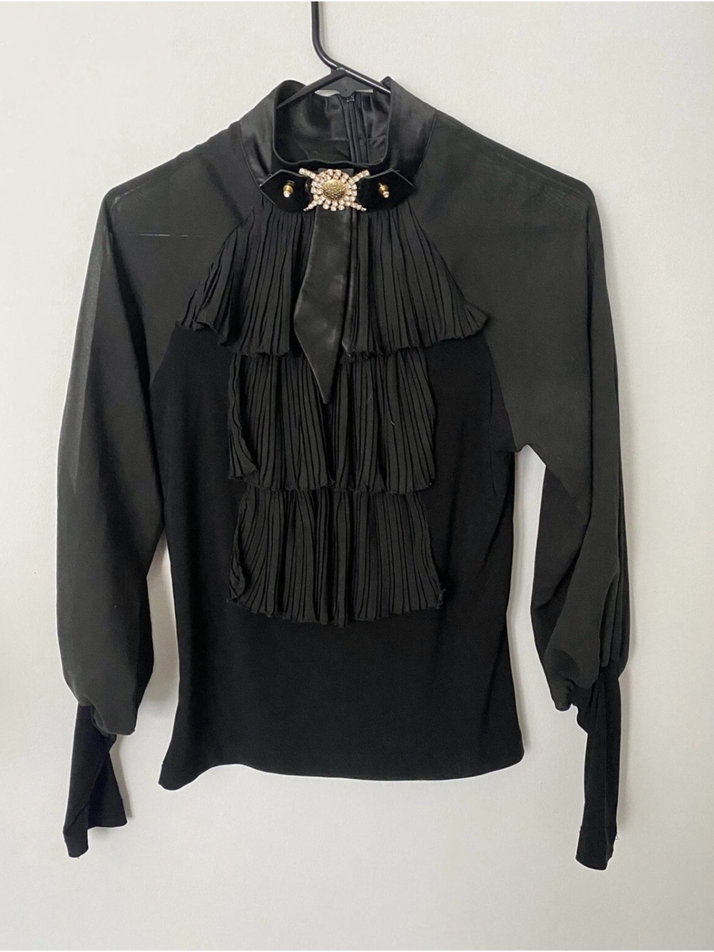 Black Ruffled High-Collar Blouse with Decorative Brooch